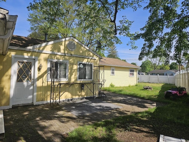 rear view of property with a patio and a shingled roof