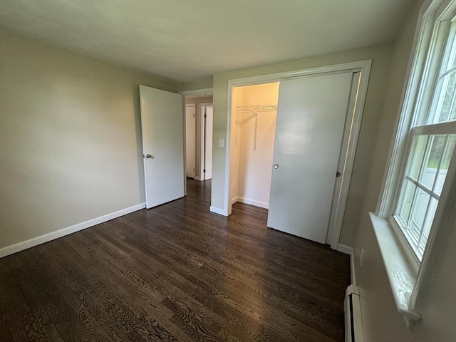 464 Church St, Raynham, MA 02767 - unfurnished bedroom with dark wood-type flooring, baseboards, a baseboard radiator, and a closet