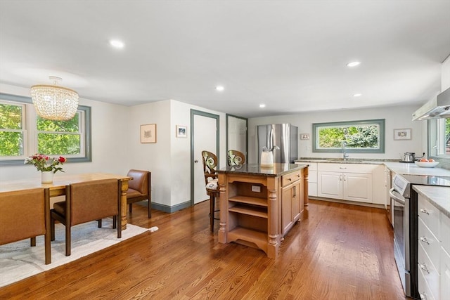 113 Bray St, Gloucester, MA 01930 - kitchen featuring appliances with stainless steel finishes, open shelves, wood finished floors, a chandelier, and white cabinets