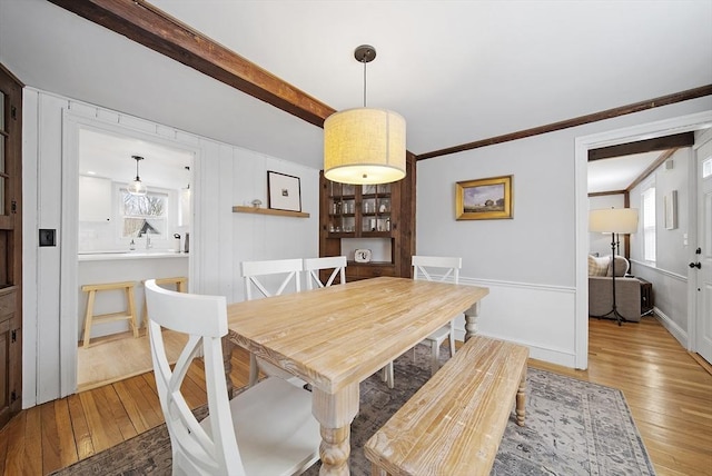 dining room featuring a wealth of natural light, wood-type flooring, and crown molding