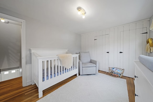 bedroom featuring a crib and wood finished floors