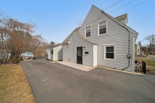 view of front of property featuring fence, driveway, and a patio area