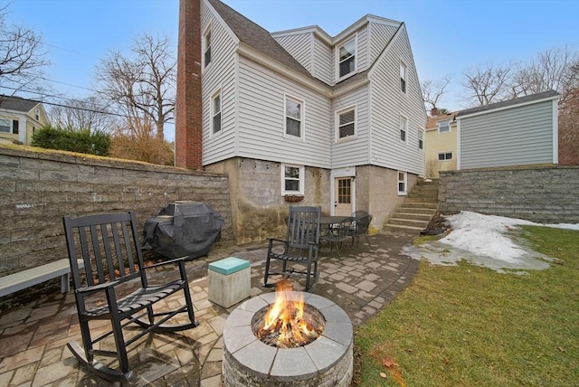 back of house with a chimney, a fire pit, and a patio