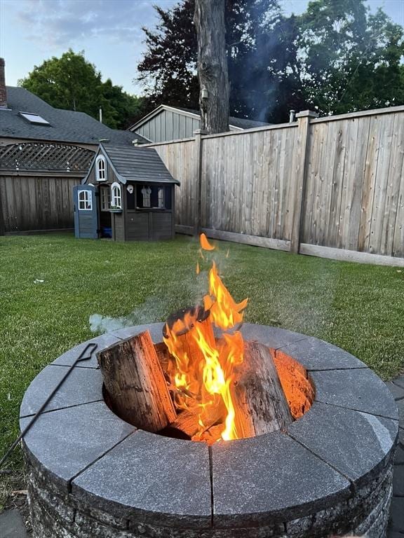 view of yard featuring an outdoor structure, a shed, a fire pit, and a fenced backyard