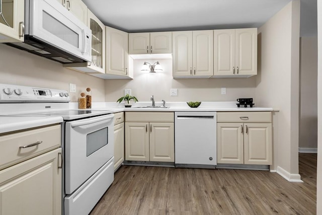 234 Low St Unit 16, Newburyport, MA 01950 - kitchen featuring white appliances, wood finished floors, light countertops, and glass insert cabinets