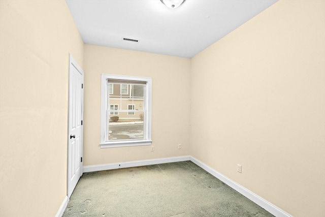 carpeted empty room featuring visible vents and baseboards