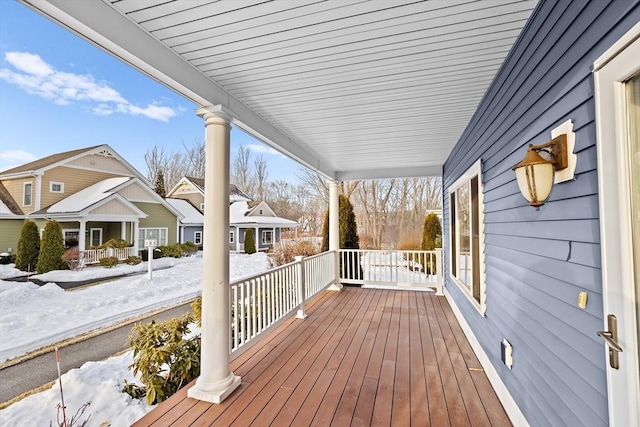 snow covered deck with a porch