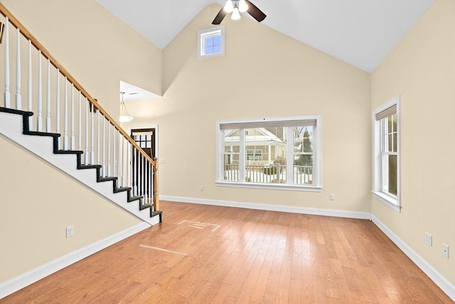 interior space with high vaulted ceiling, stairway, baseboards, and wood finished floors