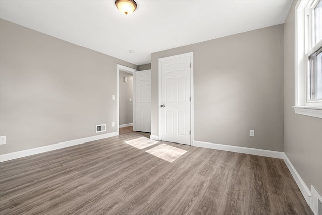 unfurnished bedroom with a closet and hardwood / wood-style floors