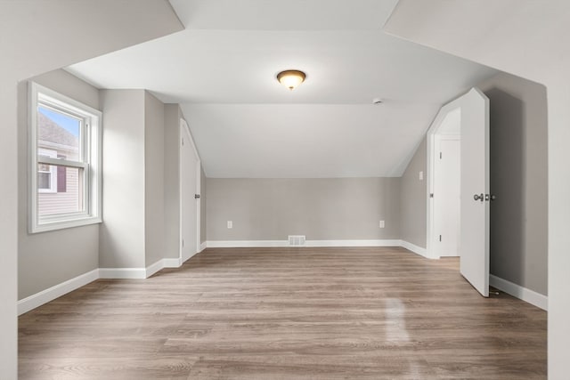 bonus room with light hardwood / wood-style floors and lofted ceiling