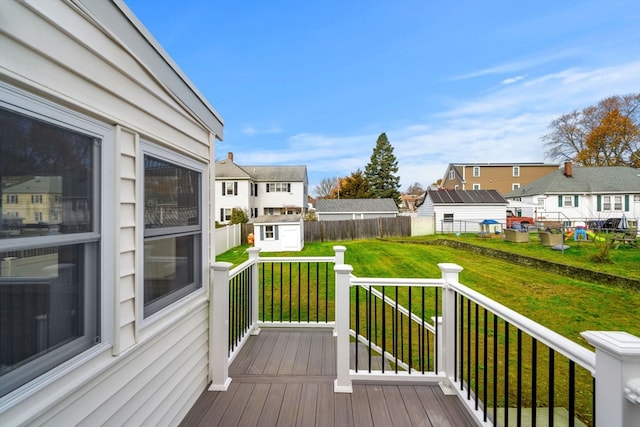 deck with a lawn and a storage shed