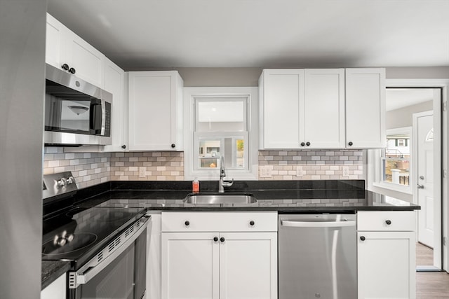 kitchen featuring a wealth of natural light, white cabinetry, appliances with stainless steel finishes, and sink