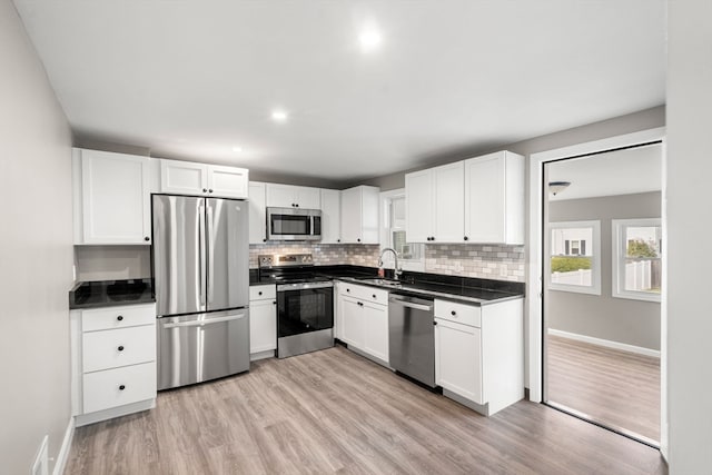 kitchen featuring stainless steel appliances, white cabinetry, sink, and light wood-type flooring