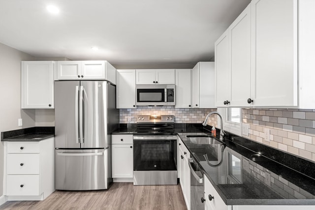 kitchen featuring appliances with stainless steel finishes, sink, light hardwood / wood-style floors, and white cabinets