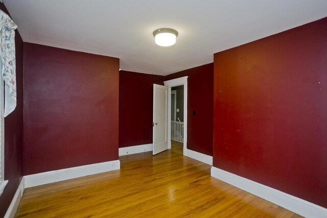 empty room featuring baseboards and wood finished floors