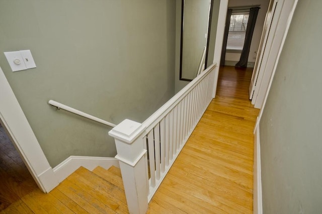 stairway with wood finished floors and baseboards