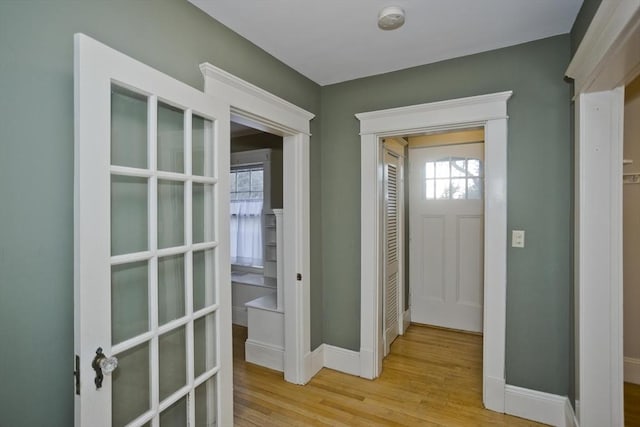 foyer entrance with light wood-type flooring and baseboards