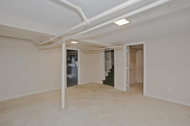 interior space featuring carpet floors, washer / clothes dryer, and baseboards