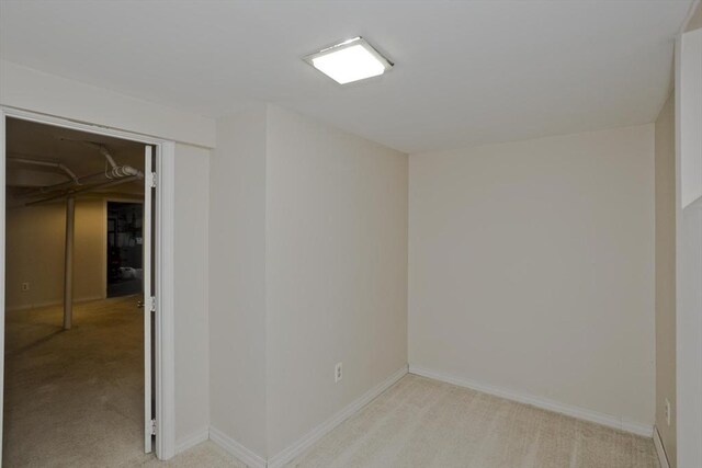 spare room with light carpet and baseboards