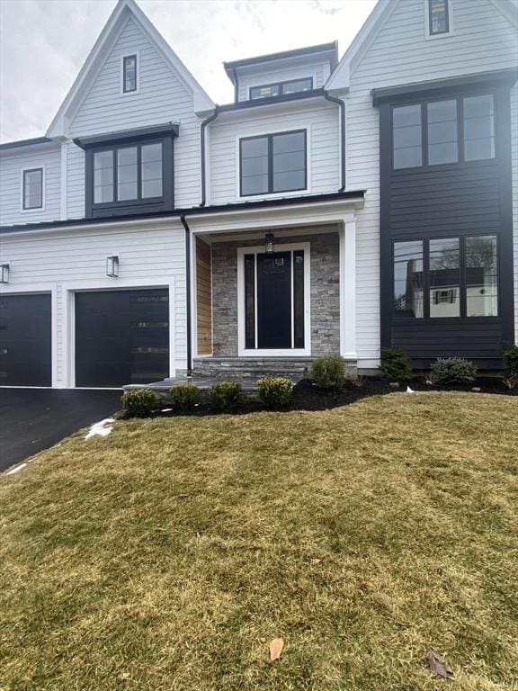 view of front of property featuring a garage and a front lawn