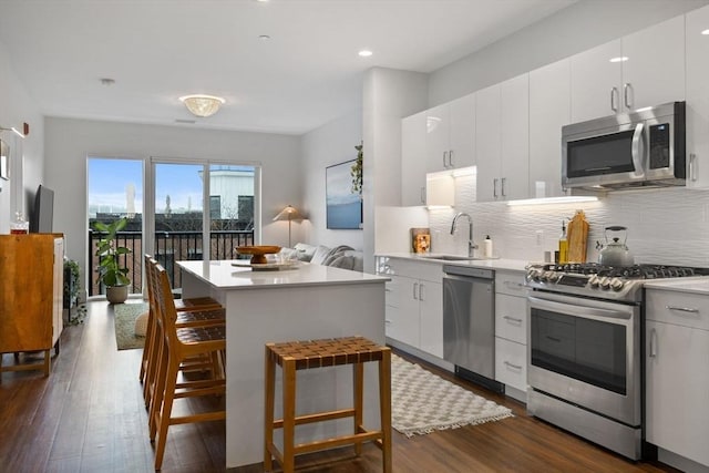 kitchen with tasteful backsplash, appliances with stainless steel finishes, sink, and white cabinetry