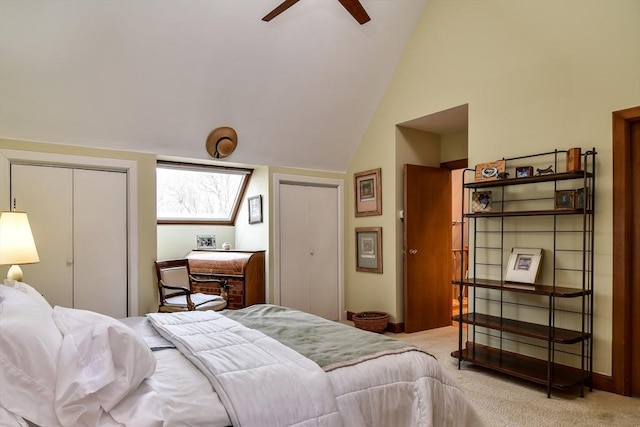 bedroom featuring multiple closets, vaulted ceiling, light carpet, and ceiling fan