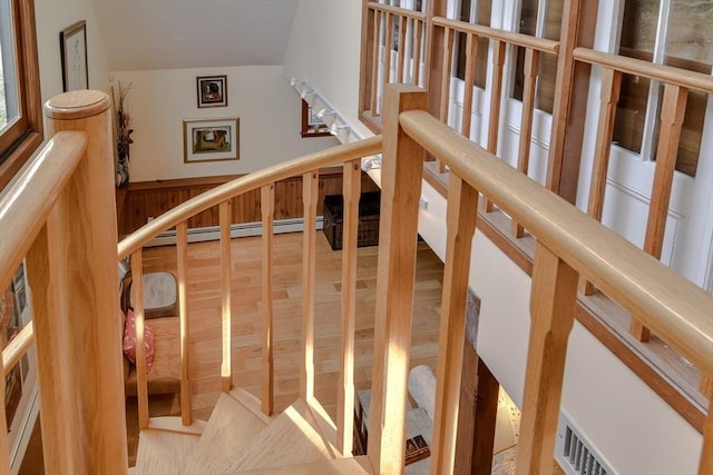 stairs with hardwood / wood-style flooring and a baseboard heating unit