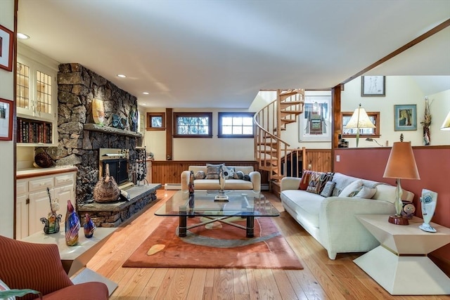 living room featuring a baseboard heating unit, a fireplace, and light wood-type flooring