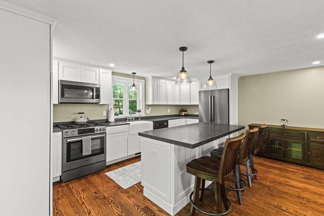 192 Furnace Ln, Pembroke, MA 02359 - kitchen with appliances with stainless steel finishes, dark wood finished floors, dark countertops, white cabinetry, and recessed lighting