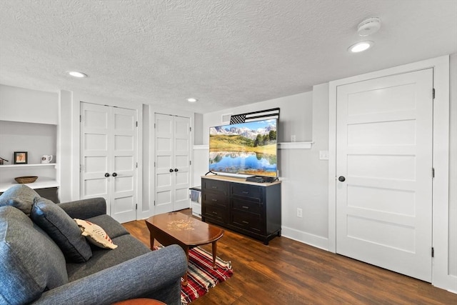 192 Furnace Ln, Pembroke, MA 02359 - living room featuring a textured ceiling, dark wood-style flooring, baseboards, recessed lighting, and built in features