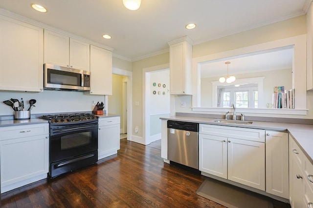 kitchen featuring stainless steel appliances, a sink, dark wood-type flooring, light countertops, and white cabinets