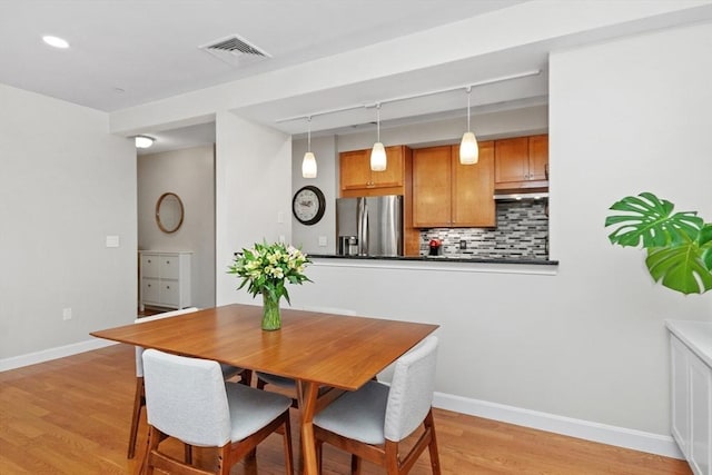 dining area featuring light hardwood / wood-style floors and rail lighting