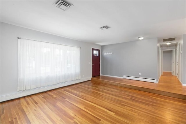 150 Gore Rd, Revere, MA 02151 - spare room with baseboard heating, light wood finished floors, and a baseboard heating unit