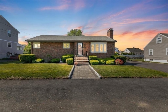 150 Gore Rd, Revere, MA 02151 - view of front of property with a chimney, a front yard, and brick siding