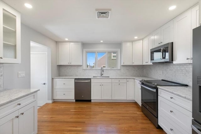 150 Gore Rd, Revere, MA 02151 - kitchen with appliances with stainless steel finishes, white cabinets, backsplash, recessed lighting, and light wood-style floors
