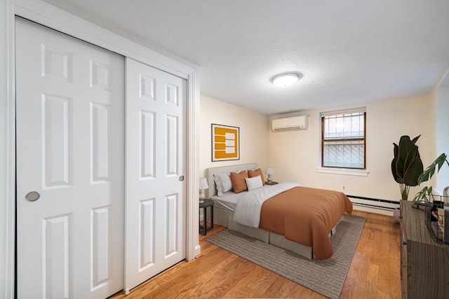 9 Hancock St Unit 1, Boston, MA 02114 - bedroom with a wall unit AC, baseboard heating, and light wood finished floors