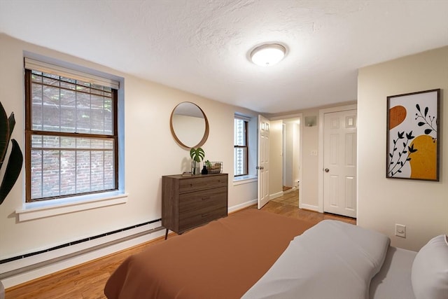 9 Hancock St Unit 1, Boston, MA 02114 - bedroom featuring a baseboard heating unit, multiple windows, a textured ceiling, and baseboards