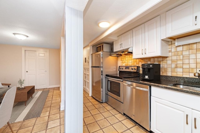 9 Hancock St Unit 1, Boston, MA 02114 - kitchen with appliances with stainless steel finishes, under cabinet range hood, white cabinetry, and tasteful backsplash