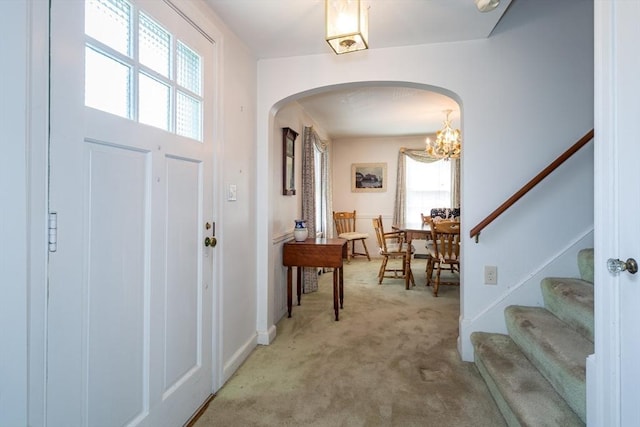 12 Bay State Rd, Natick, MA 01760 - entrance foyer with arched walkways, light carpet, a chandelier, stairway, and baseboards