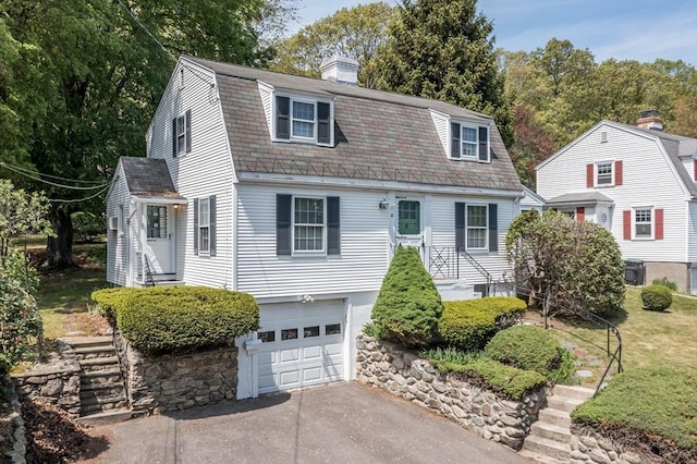 12 Bay State Rd, Natick, MA 01760 - dutch colonial featuring driveway, a garage, a chimney, a gambrel roof, and roof with shingles