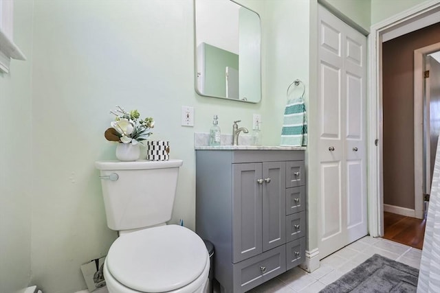 bathroom with toilet, tile patterned flooring, and vanity
