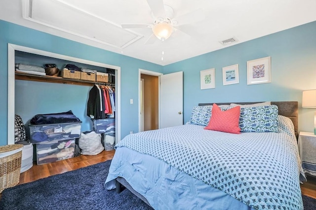 bedroom with attic access, a closet, wood finished floors, and a ceiling fan