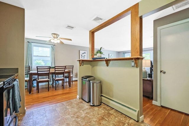 dining area with baseboard heating, healthy amount of natural light, a ceiling fan, and baseboards