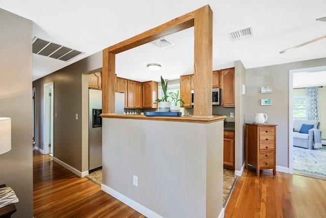 kitchen with wood finished floors, healthy amount of natural light, and appliances with stainless steel finishes