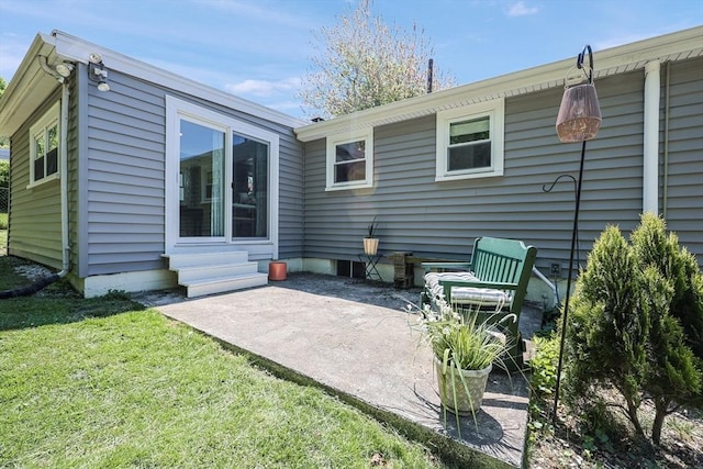 rear view of house featuring a patio, entry steps, and a yard