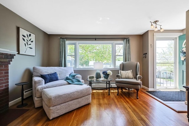 living area with hardwood / wood-style flooring, baseboards, and a baseboard radiator