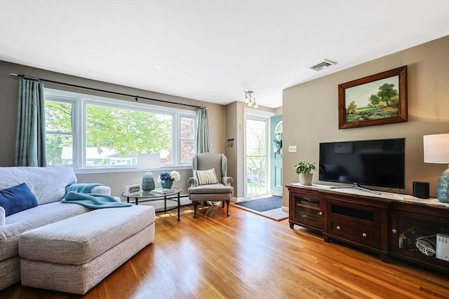 living room with light wood-style floors and a baseboard heating unit