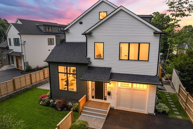 view of front of property with a garage and a lawn