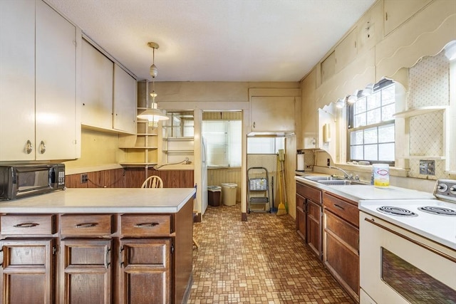 kitchen with sink, electric range, and decorative light fixtures