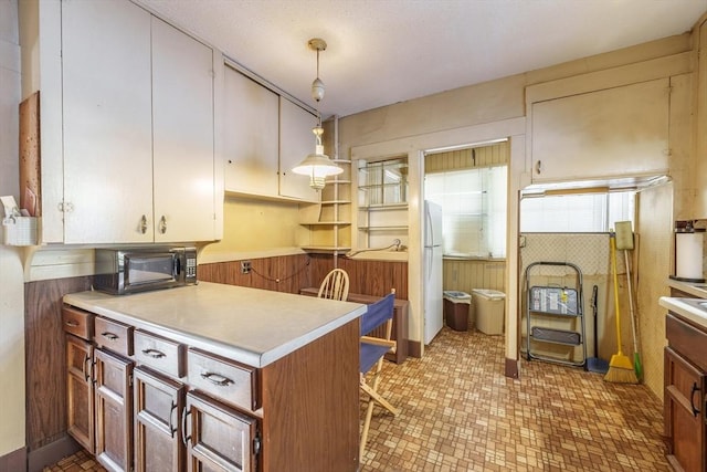 kitchen featuring pendant lighting and wood walls